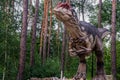 Full-size statue of allosaurus in the forest. Dinopark of Belgorod city