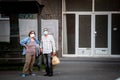 Selective blur on Old senior man and woman, couple, wearing a facemask, standing in street of Belgrade with grocery bags in summer Royalty Free Stock Photo