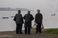 Old senior women, friends, observing the Danube river in Zemun, on Zemunski kej, during a rainy afternoon.