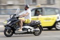 One man riding scooter in city street traffic