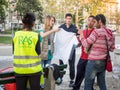 Volunteer from the NGO Refugee Aid Serbia standing in front of refugees from Syria and Afghanistan getting help and food