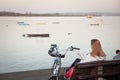 BELGRADE, SERBIA - APRIL 23, 2023: Selective blur on a young woman sitting on a bench, reading a Serbian book by her bicycle while