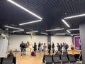 Belgrade, Serbia - 13 august 2023: Passengers with luggage stand in line at the check-in desk at the airport. Side view Royalty Free Stock Photo