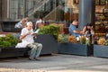 Senior old man reading a book outdoors, sitting on a public bench, in the city center of Belgrade, capital of Serbia