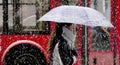 One young woman walking under umbrella in heavy snowfall in city street Royalty Free Stock Photo