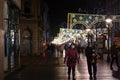 Selective blur on a Family, a mother, father and their baby walking at night in the middle of a crowd wearing face mask on Covid