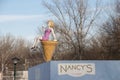 Ice cream beach shop with the sculpture of an attractive woman sitting on a cone and eating ice cream