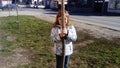 Belgrade, Serbia. February 22, 2020. A 6-year-old girl hides behind a thin tree. A child with glasses. Peekaboo