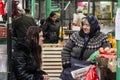 Senior Old woman in traditional clothes selling fruits and vegetables, and discussing with a younger woman on Zeleni Venac Pijaca