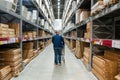 Belgrade, Serbia - January 02, 2023: Warehouse aisle in an IKEA store. Man walking i IKEA furniture warehouse area