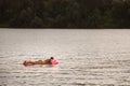 BELGRADE, SERBIA - JULY 31, 2021: Selective blur on a young man, white caucasian, swimming and floating on an air mattress on Reka