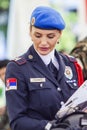 Police lady holding pamphlets dressed in her uniform