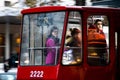 Young people riding in a tram, with graffiti and reflections, through the window