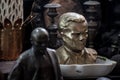 Bust of Marshal Josip broz Tito facing a small statue of Vladimir Lenin.