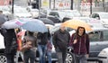 People under umbrellas crossing the street in rush hour with many cars in traffic jam on a rainy day Royalty Free Stock Photo