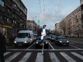 BELGRADE, SERBIA - SEPTEMBER 3, 2022: Selective blur on a Clown, street performer juggling at a traffic light, by a pedestrian