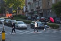 BELGRADE, SERBIA - SEPTEMBER 3, 2022: Selective blur on a Clown, street performer playing with an umbrella at a traffic light,with