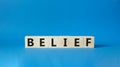 Belief symbol. Concept word Belief on wooden cubes. Beautiful blue background. Business and Belief concept. Copy space