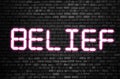 Belief word glowing in neon pink on black brick wall. Believes and statements, personal coaching and achievements concept