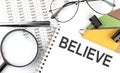 BELIEVE - the inscription of text on the Notepad, and chart. Business Royalty Free Stock Photo