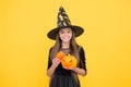 Believe in the Magic. teenage child in witch hat. cheerful kid holding pumpkin. carnival costume party. trick or treat