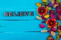 Believe word on blue wood with flower