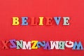 BELIEVE word on red background composed from colorful abc alphabet block wooden letters, copy space for ad text. Learning english Royalty Free Stock Photo