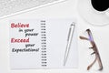 Believe in your power Exceed your expectations text on notebook