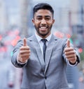 Believe and youre halfway there. a handsome young businessman standing alone and showing a thumbs up.