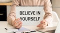Believe in yourself is written on a notepad on an office desk with office accessories Royalty Free Stock Photo