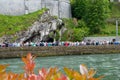 Believers and tourists near the Grotto in Lourdes. Grotto is Catholic shrine to Our Lady in Lourdes