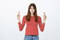 She believes in success, luck on girls side. Studio shot of confident attractive caucasian woman, holding hands up with