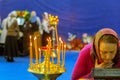 a believing woman performs the worship of the ark with a part of the relics of St. Seraphim of Sarov. Burning candles in standing