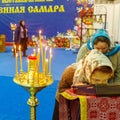 a believing woman performs the worship of the ark with a part of the relics of St. Seraphim of Sarov. Burning candles in standing
