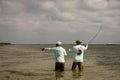 A Belizean fishing guide pointing out the school of bonefish to the fly fisherman