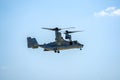 Bell Boeing V-22 Osprey Army helicopter hovering on a blue sky background.