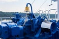 Bell, capstan and other mechanisms, painted blue, on the foredeck of the river ship, close-up