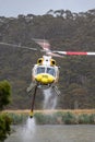 Bell 412 helicopter taking off after filling with a load of water