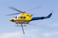 Bell 412 helicopter taking off after filling with a load of water to fight a fire Royalty Free Stock Photo