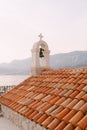 Bell on an old stone bell tower with a red tiled roof Royalty Free Stock Photo