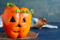 Bell pepper with black olives and lettuce as Halloween monster on blue wooden table. Space for text