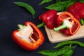 Bell pepper cut in half on a wooden cutting board on a black background. Royalty Free Stock Photo