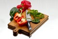 Bell peppers being cutted at wooden cutting board