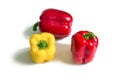 Yellow and two red bell peppers with green cuttings Royalty Free Stock Photo