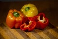 Bell peppers, whole and sliced on a wooden cutting board Royalty Free Stock Photo