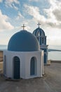 Bell tower and a blue dome of a church at sunset, Imerovigli village, Santorini island Royalty Free Stock Photo