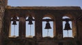 The bell tower or campanario of historic Mission San Juan Capistrano. Church bells silhouetted against the sky.