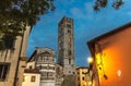 Bell tower of Chiesa di San Frediano catholic church and building with street lamp light on Piazza del Collegio square in historic