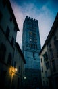 Bell tower of Chiesa di San Frediano catholic church view through narrow street with lamp light in historical centre of old mediev