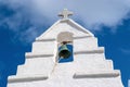 Bell tower with cross in Mykonos, Greece. Chapel building detail architecture. White church on cloudy blue sky. Religion Royalty Free Stock Photo